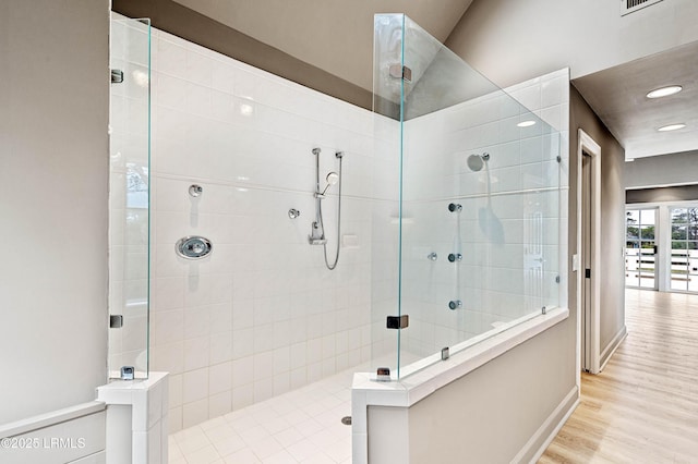 bathroom with walk in shower, wood finished floors, baseboards, and recessed lighting