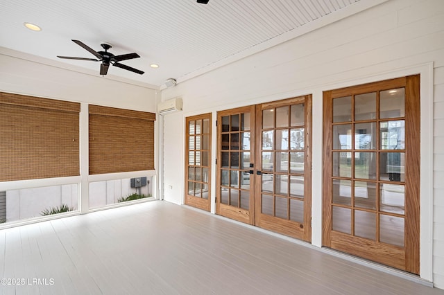 unfurnished sunroom with french doors, a wall mounted AC, and a ceiling fan