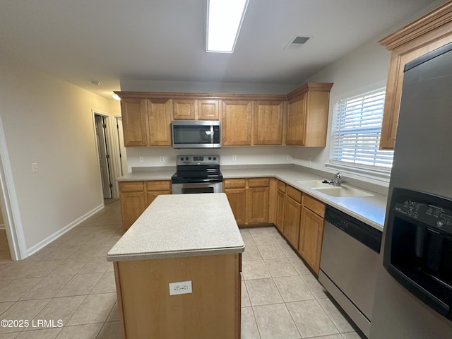 kitchen featuring stainless steel appliances, a center island, light countertops, and light tile patterned floors