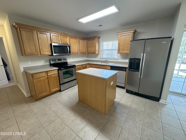 kitchen with light tile patterned floors, stainless steel appliances, a sink, and light countertops