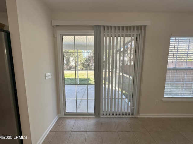 doorway featuring tile patterned flooring and baseboards