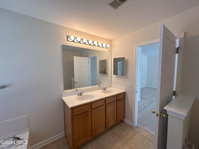 full bath featuring double vanity, baseboards, visible vents, and a sink