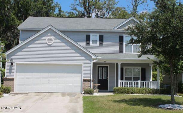 66 Shadow Moss Dr, Beaufort, SC 29906 - traditional home with covered porch, concrete driveway, brick siding, and an attached garage