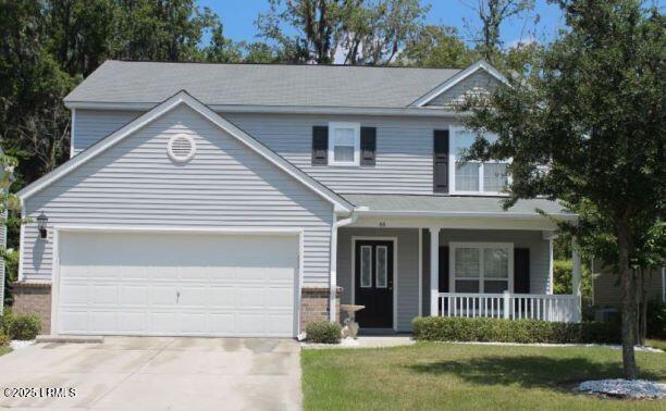 traditional home with covered porch, concrete driveway, brick siding, and an attached garage