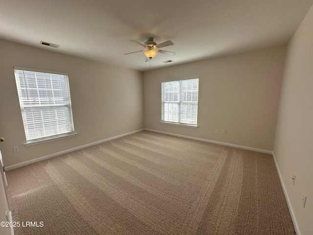 empty room with a ceiling fan, light carpet, visible vents, and baseboards