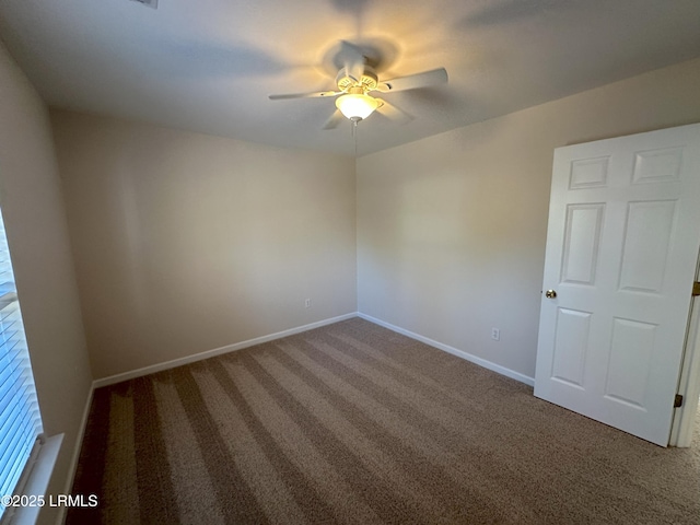 empty room featuring carpet flooring, a ceiling fan, and baseboards