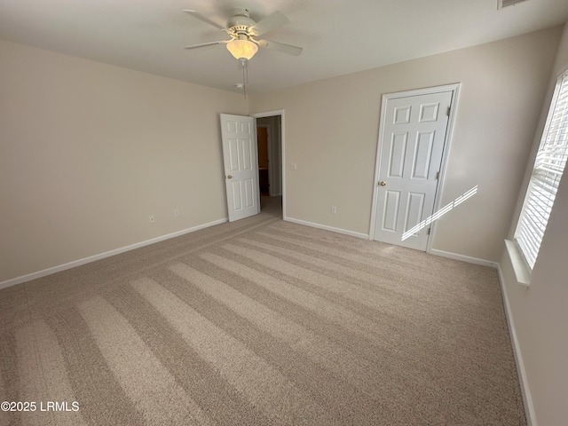 unfurnished bedroom with light carpet, a ceiling fan, and baseboards