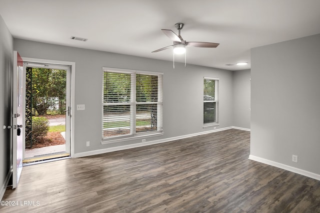 unfurnished room with a wealth of natural light, dark hardwood / wood-style floors, and ceiling fan