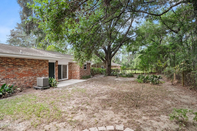 view of yard with central AC and a patio