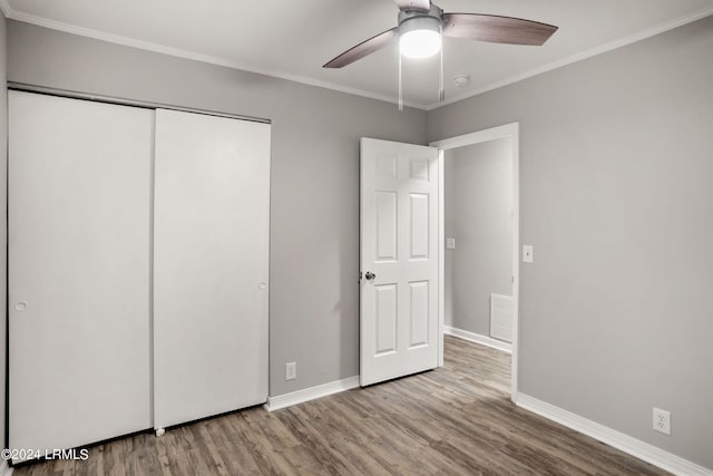 unfurnished bedroom with crown molding, light hardwood / wood-style floors, ceiling fan, and a closet