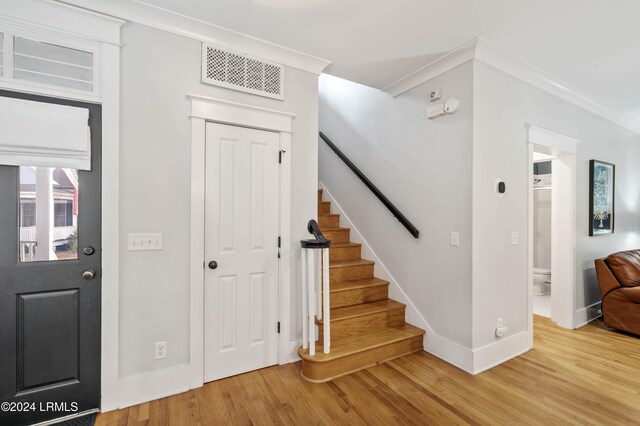 foyer featuring ornamental molding and hardwood / wood-style floors