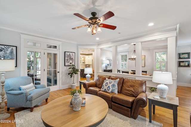 living room with crown molding, plenty of natural light, and light wood-type flooring