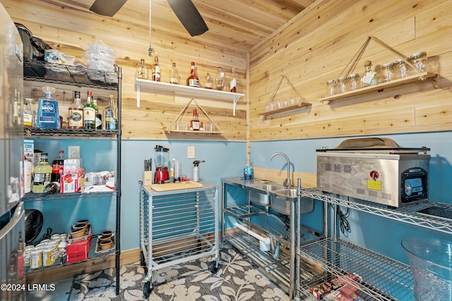 interior space with ceiling fan, wood ceiling, wooden walls, and indoor wet bar