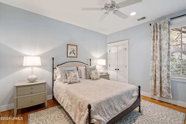 bedroom with light hardwood / wood-style floors, a closet, and ceiling fan