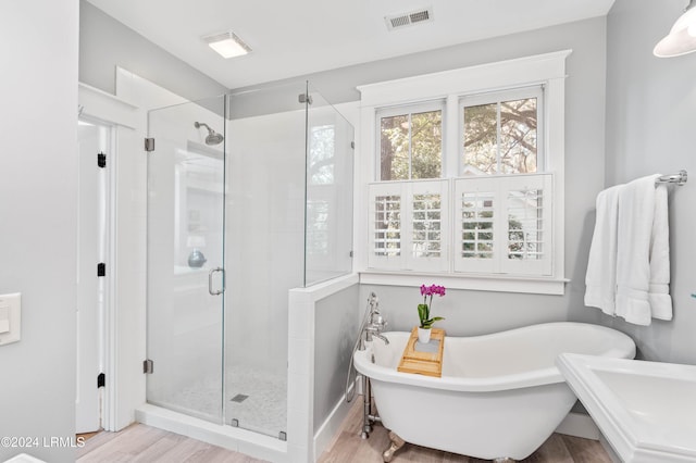 bathroom featuring hardwood / wood-style flooring and shower with separate bathtub