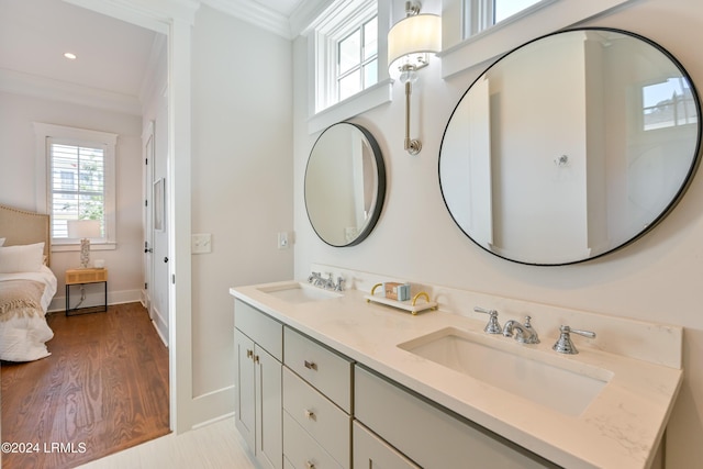 bathroom featuring ornamental molding, wood-type flooring, and vanity