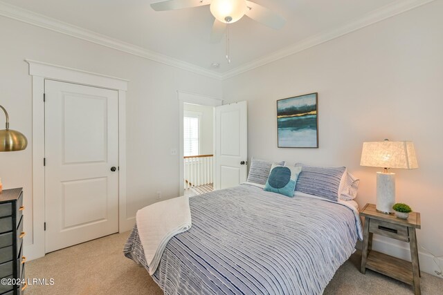 bedroom with ornamental molding, light colored carpet, and ceiling fan