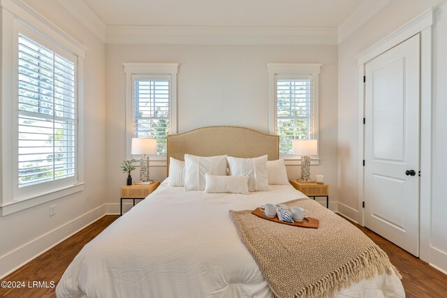 bedroom with dark hardwood / wood-style flooring and crown molding