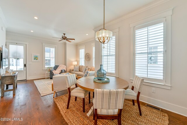 dining room featuring dark hardwood / wood-style flooring, ceiling fan with notable chandelier, and ornamental molding