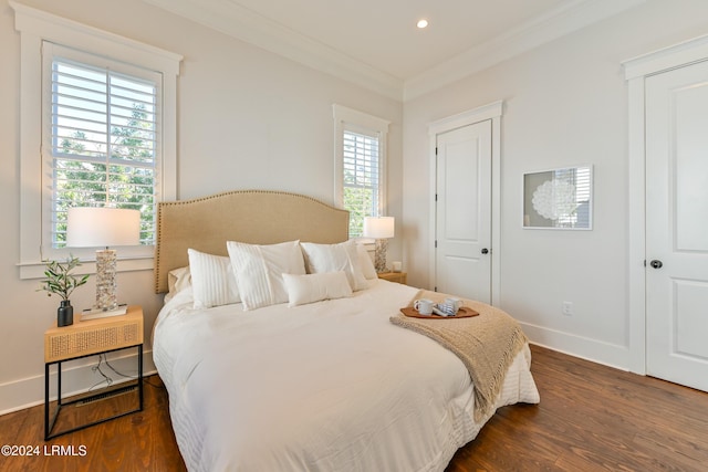 bedroom with dark hardwood / wood-style flooring and crown molding