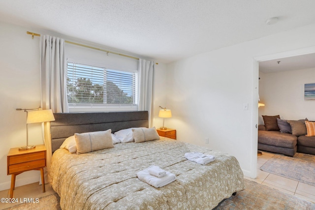 bedroom featuring a textured ceiling and light tile patterned floors