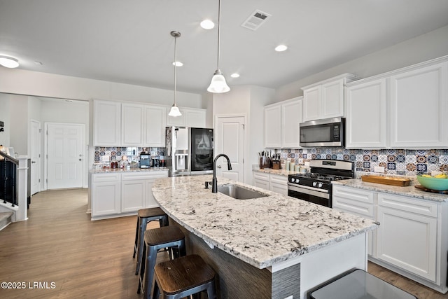 kitchen with stainless steel appliances, white cabinets, and a sink