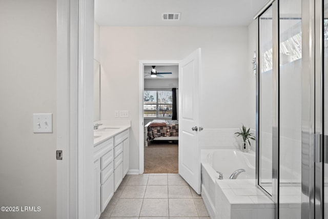 ensuite bathroom featuring ensuite bathroom, tile patterned flooring, visible vents, a bath, and double vanity