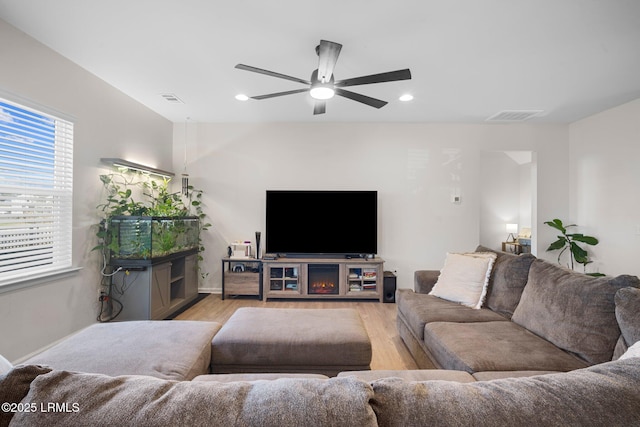 living room with light wood-type flooring, visible vents, and recessed lighting