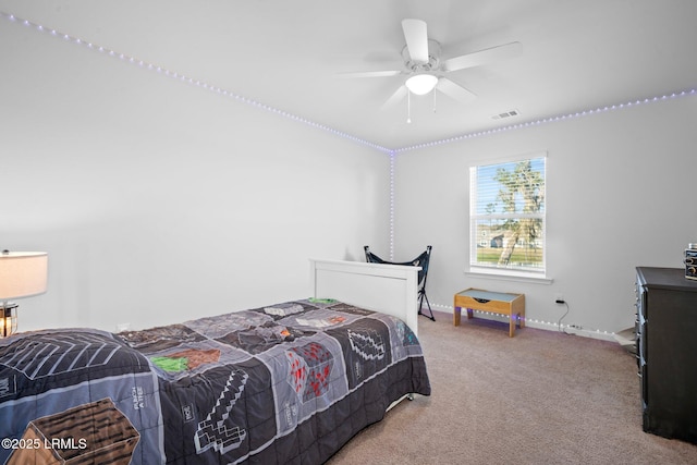 carpeted bedroom featuring a ceiling fan, visible vents, and baseboards