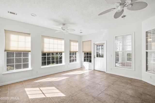 unfurnished sunroom with a ceiling fan and visible vents