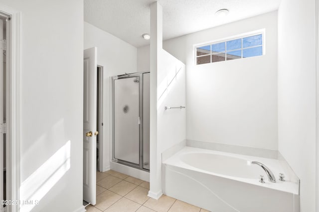 bathroom with tile patterned flooring, a shower stall, a textured ceiling, and a garden tub