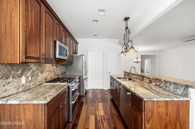 kitchen featuring visible vents, dark wood-type flooring, light stone countertops, stainless steel appliances, and a sink