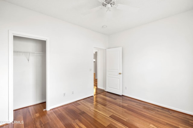 unfurnished bedroom featuring a ceiling fan, wood finished floors, a closet, and baseboards