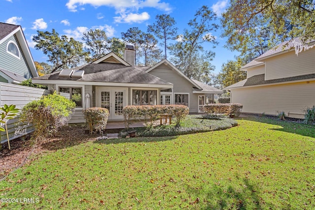 rear view of house with french doors and a yard