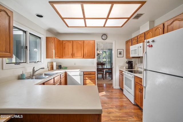 kitchen featuring sink, light hardwood / wood-style flooring, white appliances, and kitchen peninsula