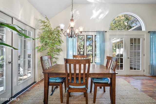 dining area with dark hardwood / wood-style flooring, vaulted ceiling, french doors, and a chandelier