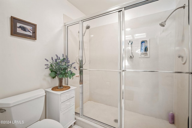 bathroom featuring toilet and an enclosed shower