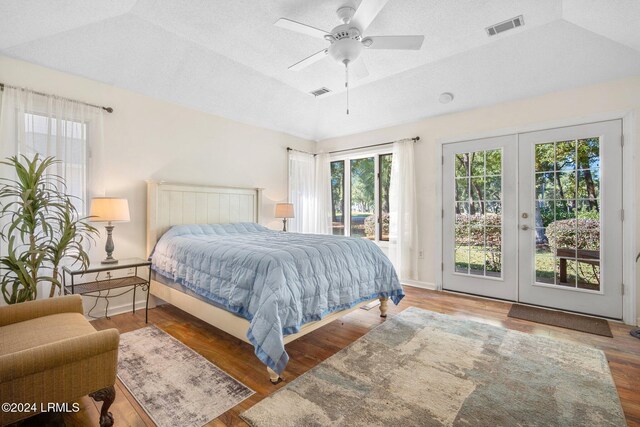 bedroom with french doors, lofted ceiling, access to outside, a tray ceiling, and ceiling fan