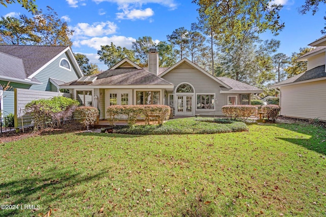 rear view of property featuring french doors and a yard