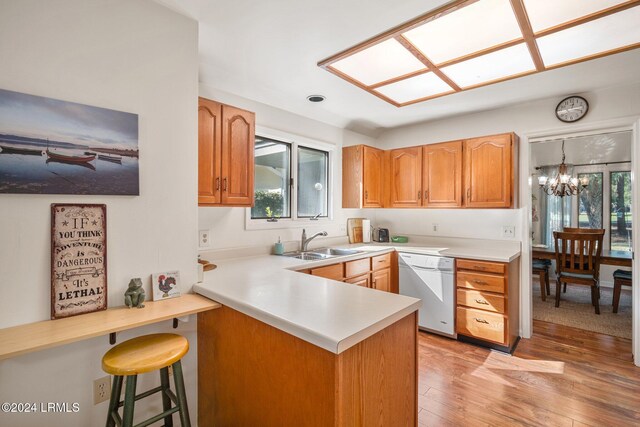 kitchen featuring white dishwasher, sink, kitchen peninsula, and a healthy amount of sunlight