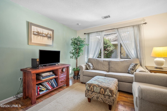 living room with dark wood-type flooring and a textured ceiling