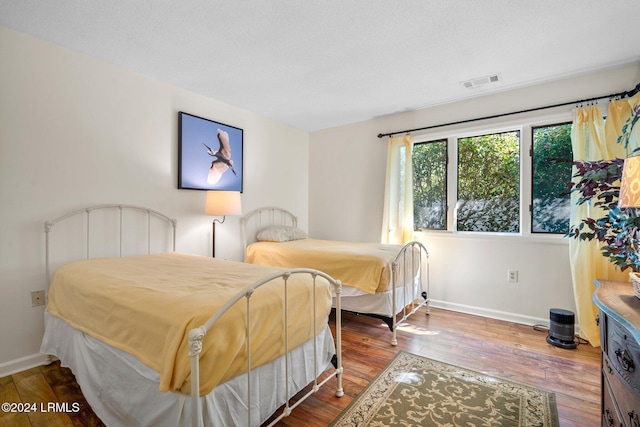 bedroom featuring wood-type flooring and a textured ceiling