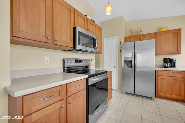 kitchen featuring light countertops, brown cabinets, light tile patterned floors, hanging light fixtures, and stainless steel appliances