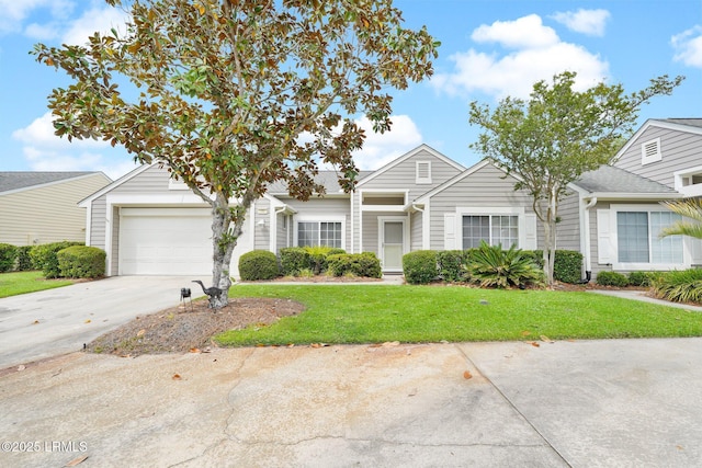 view of property with an attached garage, concrete driveway, and a front yard
