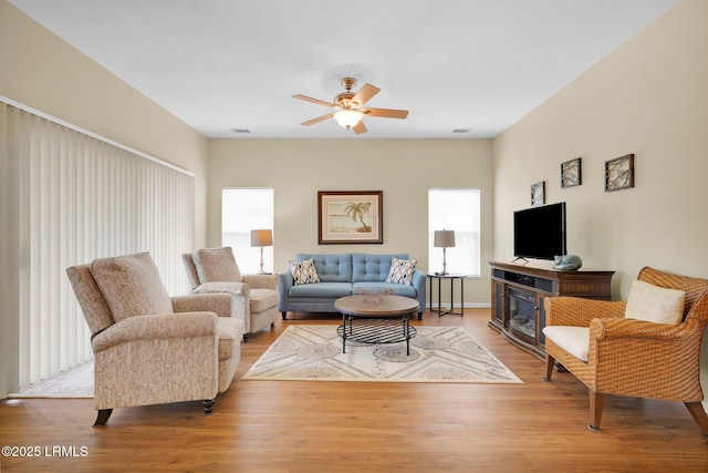 living area featuring visible vents, ceiling fan, and wood finished floors