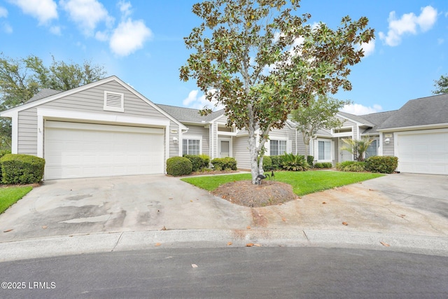 townhome / multi-family property featuring concrete driveway, a front lawn, and a garage