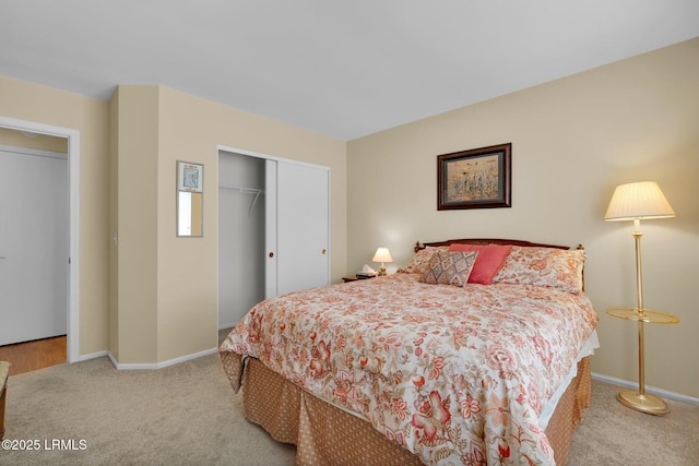 carpeted bedroom with a closet and baseboards