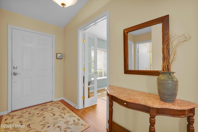 entryway with baseboards and light wood finished floors