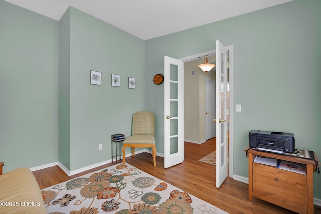 sitting room with baseboards, french doors, and wood finished floors