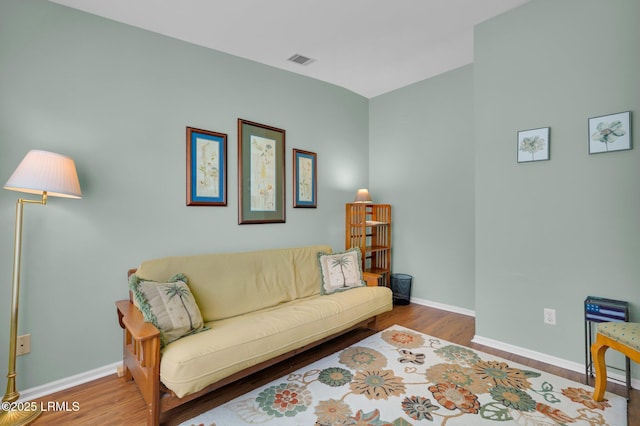 living area with baseboards, wood finished floors, and visible vents